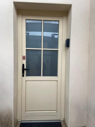 a white door with a window on a building at Le Miribel in Miribel