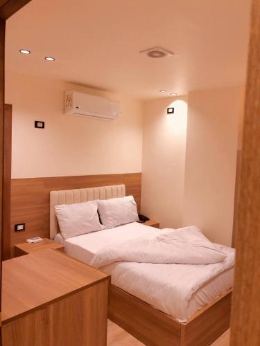 a bedroom with a bed with a nightstand and a bed sidx sidx sidx sidx at Pyramids INN View in Cairo