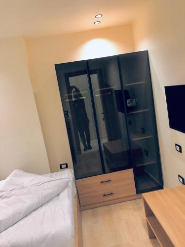 a bedroom with a bed and a large glass cabinet at Pyramids INN View in Cairo