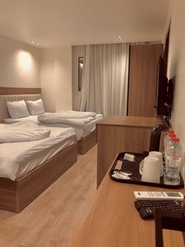 a hotel room with two beds and a desk with a computer at Pyramids INN View in Cairo