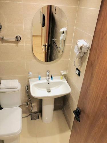 a bathroom with a sink and a mirror and a toilet at Pyramids INN View in Cairo
