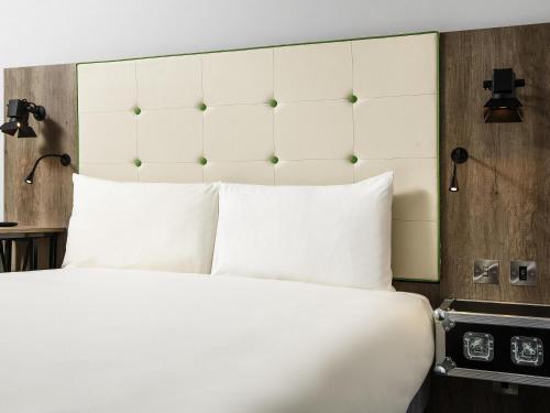 a bedroom with a large bed with white pillows at ibis Styles London Ealing in London