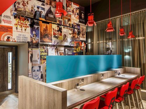 a bar with red chairs and a blue counter at ibis Styles London Ealing in London