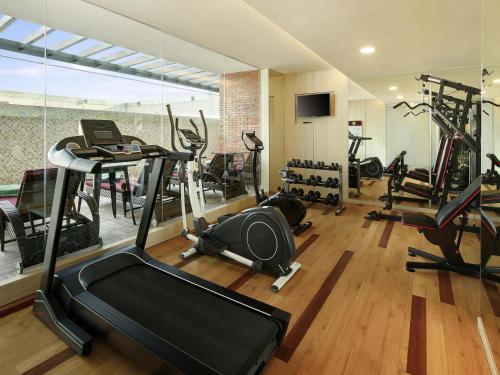 a gym with several treadmills and elliptical machines at Ibis Styles Makassar Sam Ratulangi in Makassar