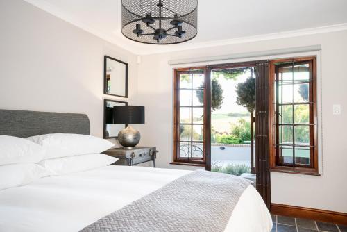 a bedroom with a bed and a window at Avemore Orchard Apartment - with full Backup power in Stellenbosch