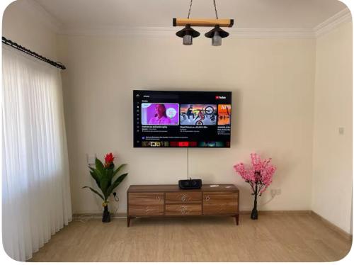 Una sala de estar con un televisor de pantalla plana en la pared. en A Spacious Villa to Entertain, en Aglantzia