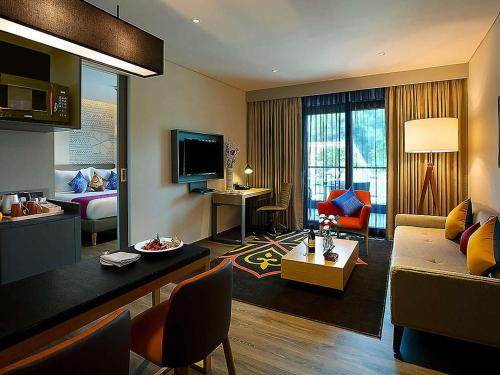 a living room with a couch and a bedroom at Grand Mercure Mysore - An Accor Brand in Mysore