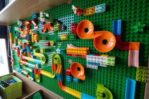 a green lego wall with lots of toys on it at Hakuna Stays in Makassar