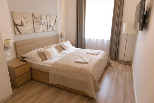 een slaapkamer met een bed met twee borden erop bij JobelHome Castle District Apartments in Boedapest