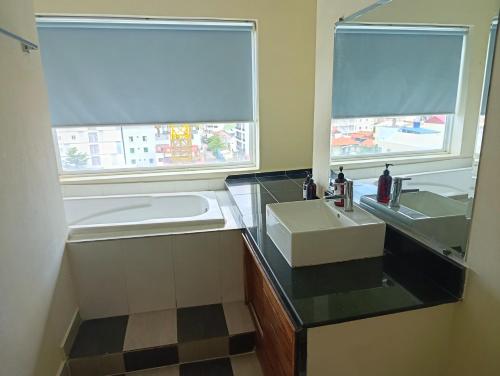 a bathroom with a sink and a large window at Sai & Su Hotel in Phnom Penh