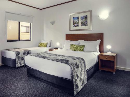 a hotel room with two beds and two lamps at Mercure Darwin Airport Resort in Darwin