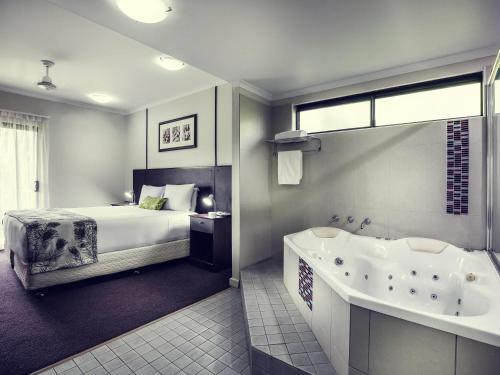 a bedroom with a bed and a bath tub and a bed sidx sidx sidx sidx at Mercure Darwin Airport Resort in Darwin