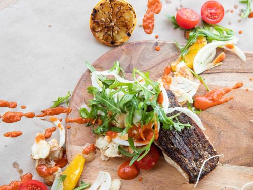 a plate of food with a fish on a cutting board at Mercure Darwin Airport Resort in Darwin