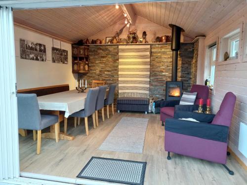 ein Esszimmer mit Tisch und Stühlen und einem Kamin in der Unterkunft Moderne hytte på Tingvoll nær sjø og turterreng in Tingvoll