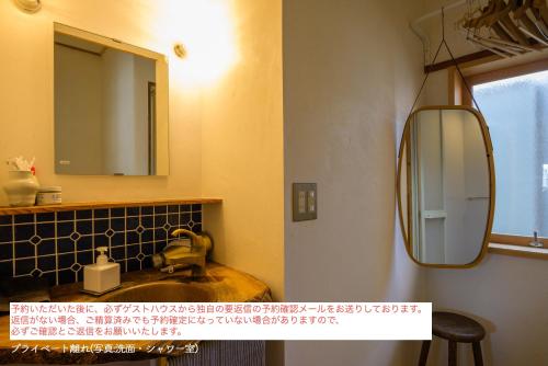 a bathroom with a sink and a mirror at Yanagawa Guesthouse HORIWARI 柳川の観光エリアにある静かな日本のゲストハウス in Yanagawa