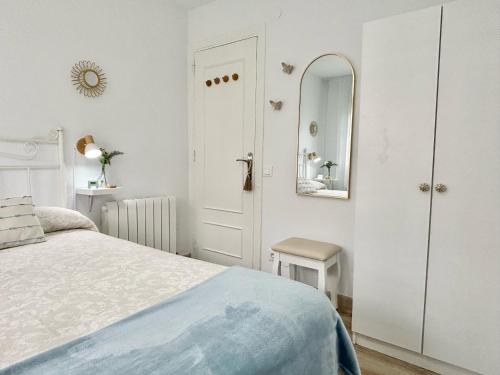 a white bedroom with a bed and a mirror at "LAS CAMELIAS SOMO" un lugar para desconectar!! Vistas al MAR!! in Somo