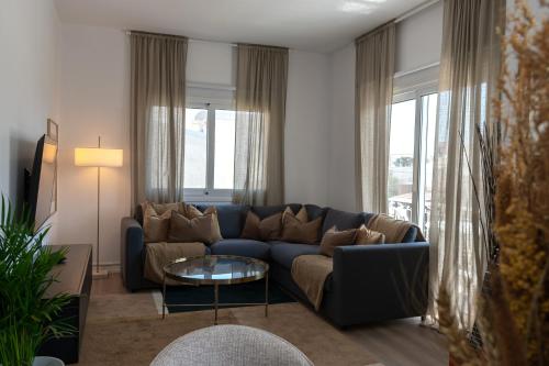 a living room with a blue couch and a table at Limassol Sunbliss by Staycom in Limassol