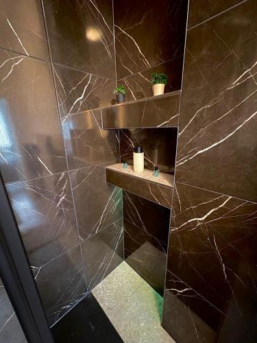 a bathroom with brown marble walls and shelves at Aura Apartment Herne in Herne