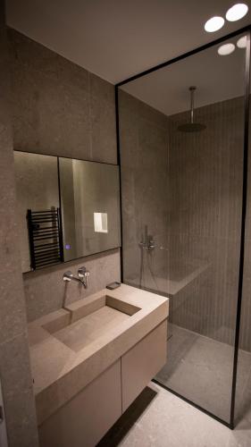 a bathroom with a sink and a shower at Villa Five Hotel in Lushnjë