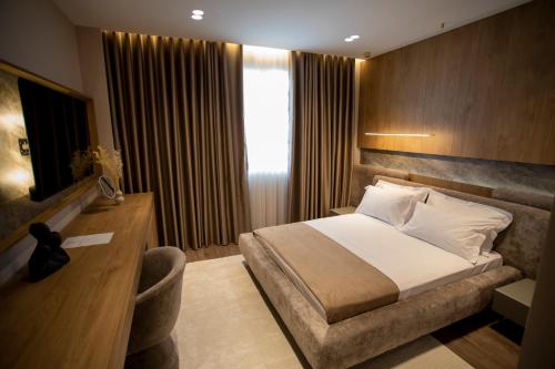 a hotel room with a bed and a desk at Villa Five Hotel in Lushnjë