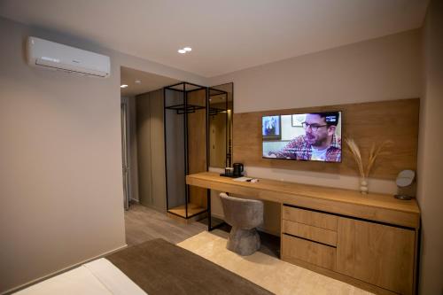 a room with a television on a wall at Villa Five Hotel in Lushnjë