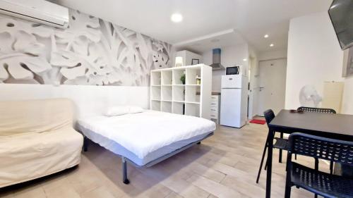 Un dormitorio con una cama, una mesa y un frigorífico. en Aptos Sol y Playa Benalmádena, en Benalmádena