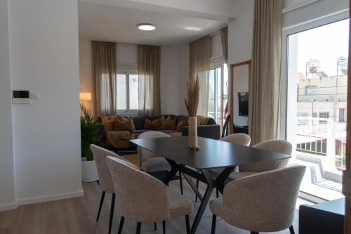 a dining room with a table and chairs and a couch at Limassol Sunbliss by Staycom in Limassol