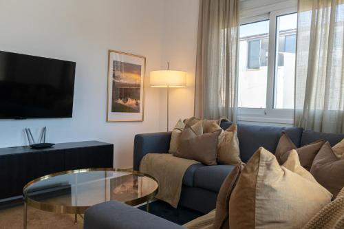 a living room with a blue couch and a glass table at Limassol Sunbliss by Staycom in Limassol
