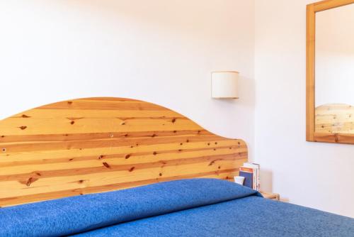a bed with a wooden headboard in a bedroom at Argentario Garden House in Albinia