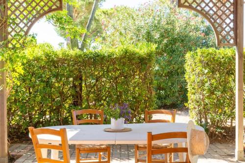 a white table with chairs and a white vase on it at Argentario Garden House in Albinia