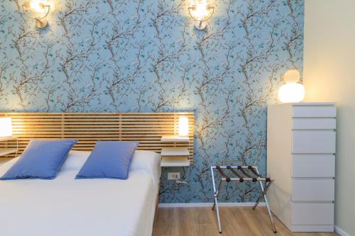 a bedroom with a bed and blue wallpaper at I-Host Apartment - Ripamonti 205 in Milan