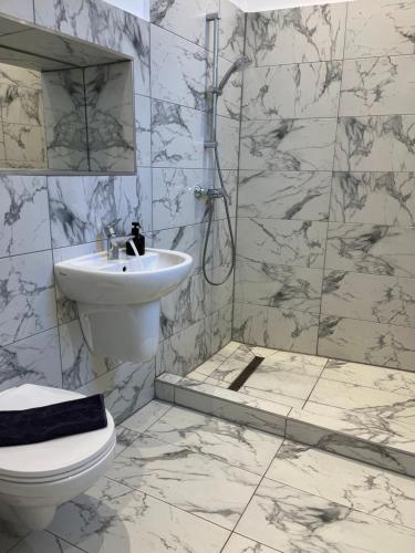 Un baño blanco con lavabo e inodoro. en Ultra-Central Cozy Studio, Steps from Everything, en Cluj-Napoca