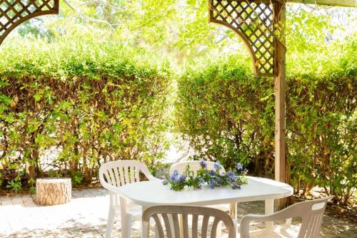 a white table and chairs under a gazebo at Argentario Garden House in Albinia