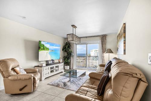 a living room with a couch and a tv at 1511 Seas The Day- Batiki West Unit #504 condo in Fort Myers Beach