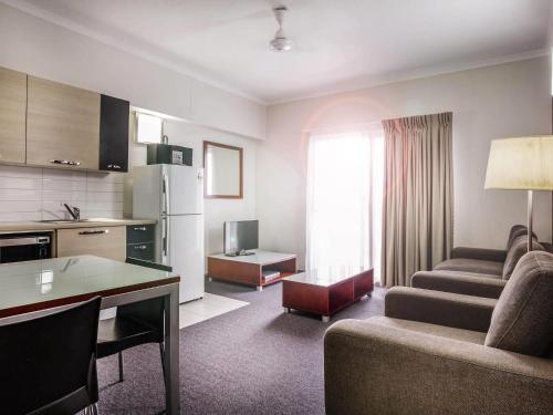 a kitchen and living room with a couch and a table at Novotel Darwin Airport in Darwin
