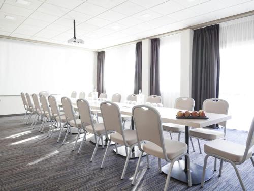 a conference room with a long table and chairs at Novotel Brescia Due in Brescia