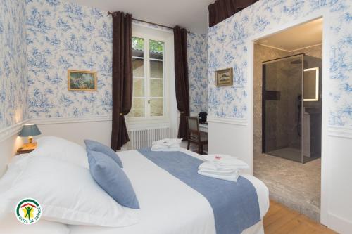 a bedroom with a bed with blue wallpaper at Château de la Rochetière in Marcilloles