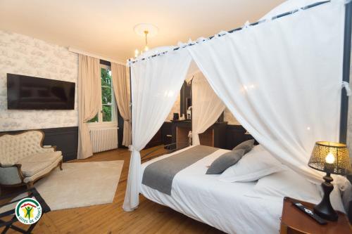 a bedroom with a bed with a canopy at Château de la Rochetière in Marcilloles