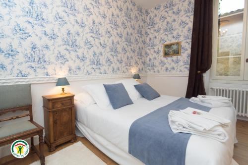 a bedroom with two beds and blue and white wallpaper at Château de la Rochetière in Marcilloles
