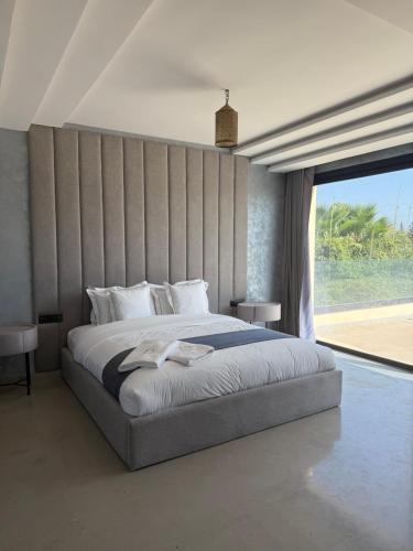 a bedroom with a large bed and a large window at AD Villa in Marrakesh
