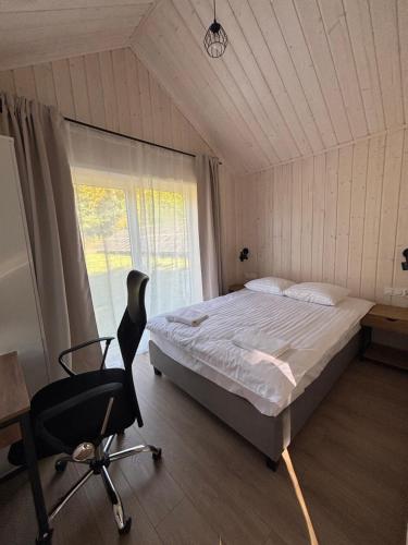 a bedroom with a bed and a desk and a chair at Domki nad Krzyworzeką in Dobczyce