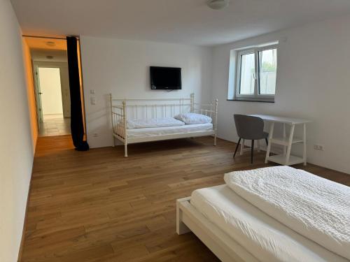 a bedroom with two beds and a table and a desk at Großzügiges Apartment in Biberach an der Riss in Biberach an der Riß