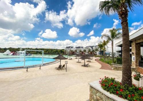 una piscina in un resort con tavoli e ombrelloni di Serenity@TheBlyde a Pretoria