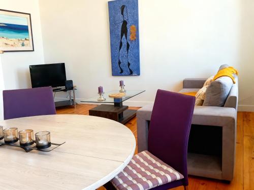 a living room with a table and a couch at Cocon des thermes in Vichy