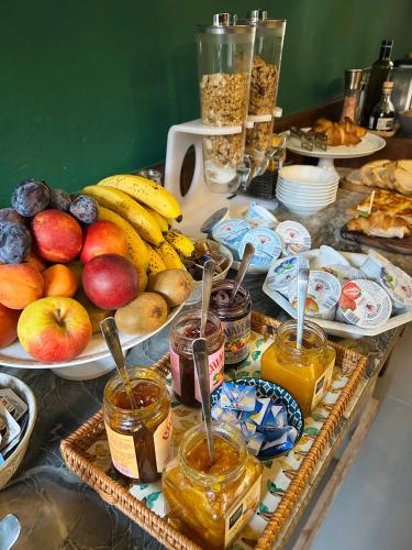 a table topped with baskets of fruit and other food at Art Hotel Pietrasanta in Pietrasanta
