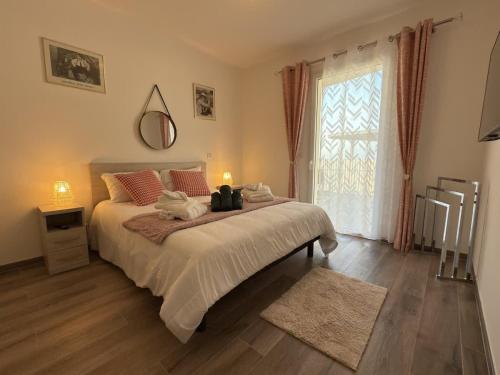 a bedroom with a bed and a large window at Exceptionnel appartement avec vue mer in Vendres-Plage