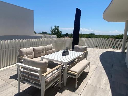 a white table and two chairs on a patio at Exceptionnel appartement avec vue mer in Vendres-Plage