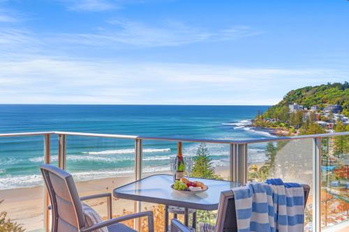 a table and chairs on a balcony with the ocean at Pacific Regis Beachfront Holiday Apartments in Gold Coast