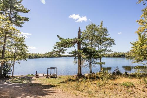 a picnic table on the shore of a lake at Sunken Escapes Cabin 7 in New Minas