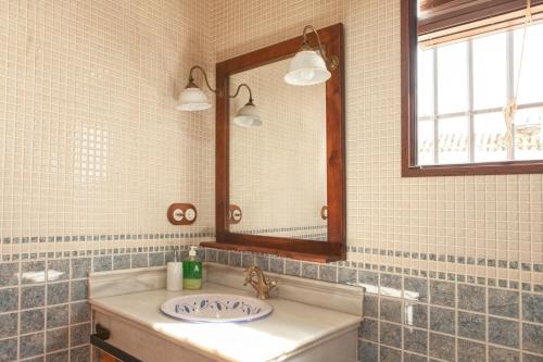 un bagno con lavandino e specchio di Casa Rural El Membrillo a Carcabuey